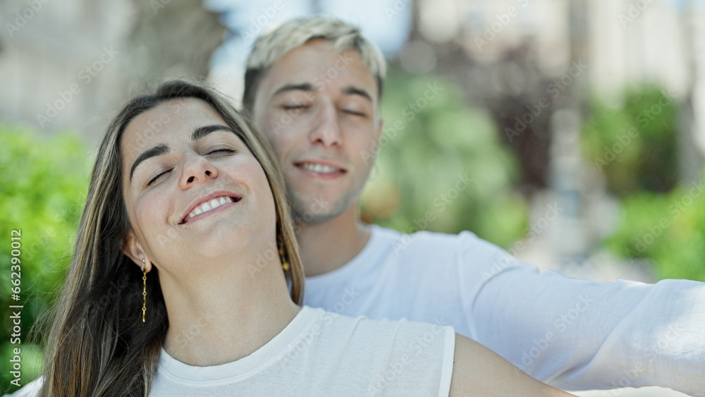 Beautiful couple smiling confident breathing with arms open at park Beautiful couple smiling confident breathing with arms open at park
