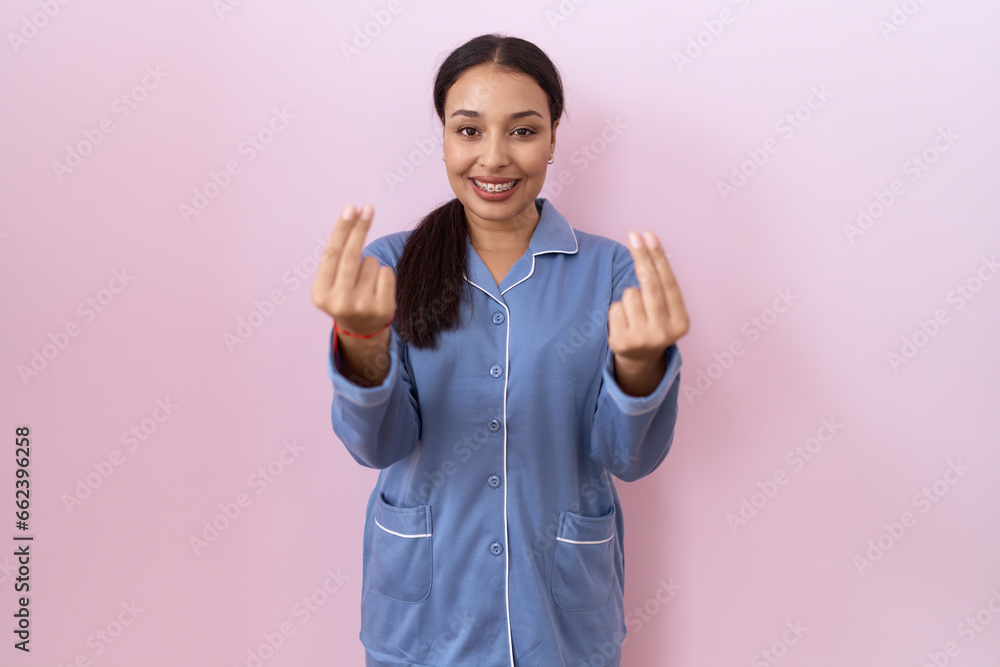Young arab woman wearing blue pajama doing money gesture with hands, asking for salary payment, millionaire business Young arab woman wearing blue pajama doing money gesture with hands, asking for salary payment, millionaire business