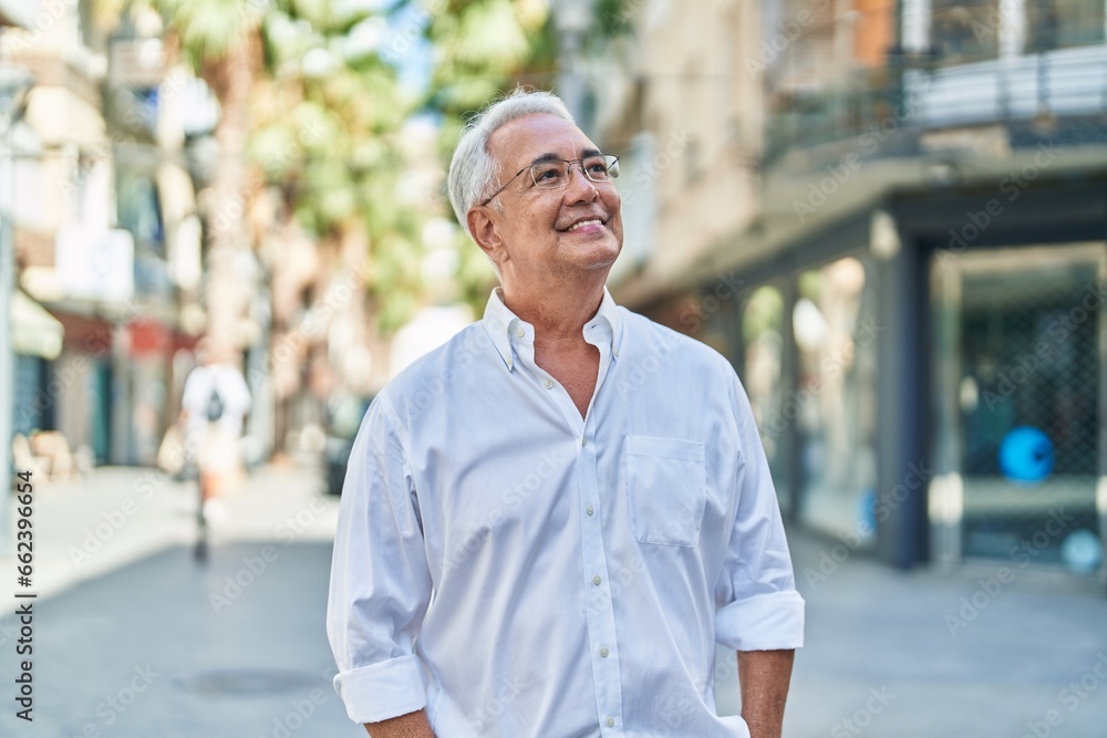 Obraz premium Middle age grey-haired man smiling confident looking to the sky at street
