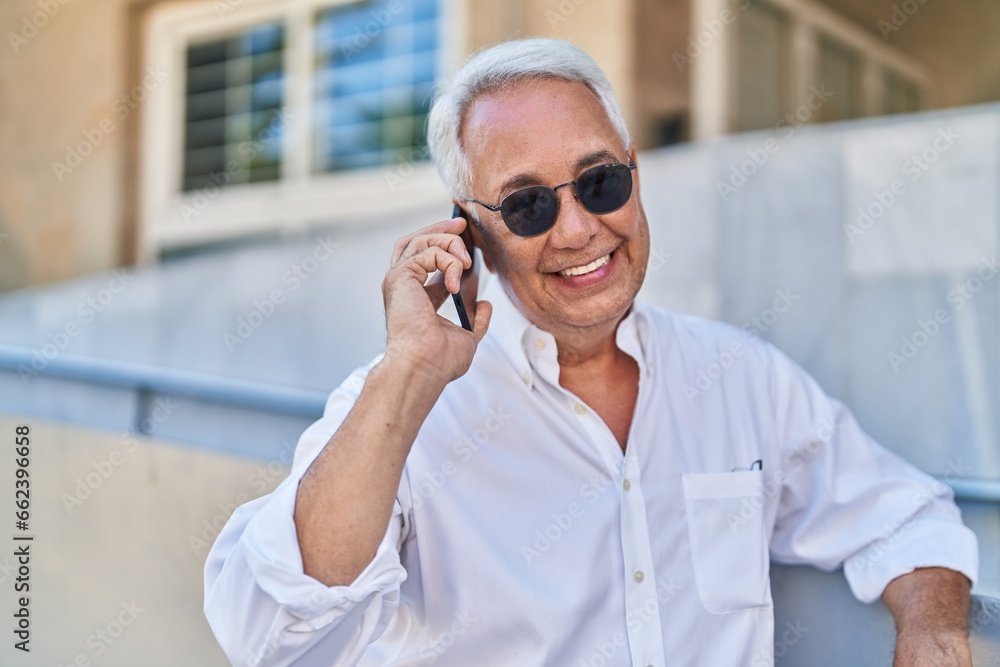 Middle age grey-haired man smiling confident talking on the smartphone at street Middle age grey-haired man smiling confident talking on the smartphone at street