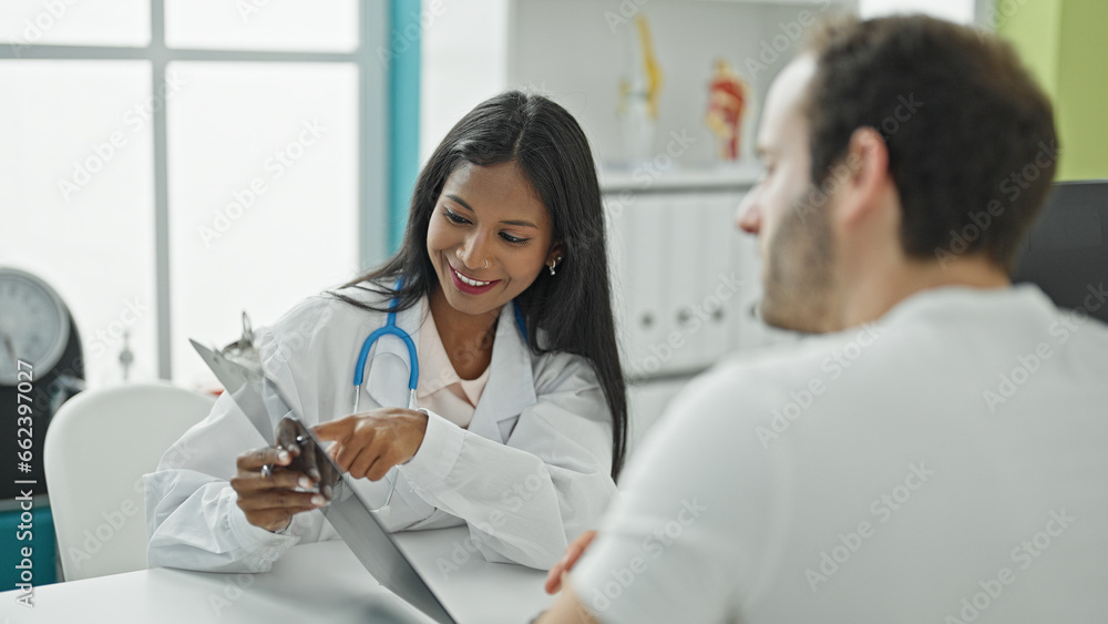Doctor and patient sitting on table showing medical report at the clinic Doctor and patient sitting on table showing medical report at the clinic