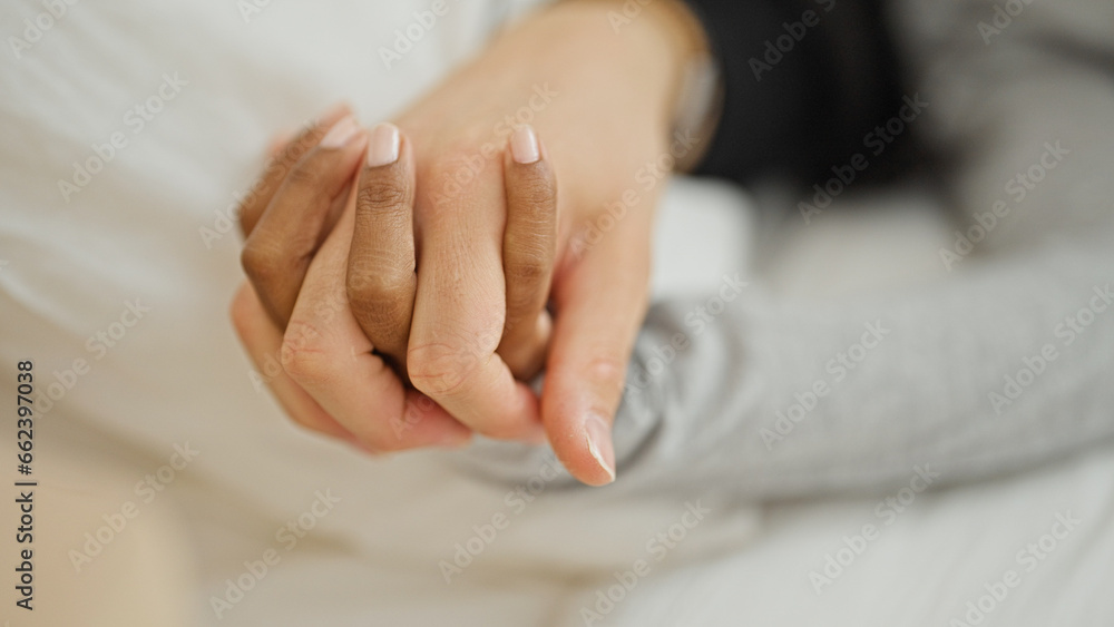 Beautiful couple lying on bed with hands together at bedroom Beautiful couple lying on bed with hands together at bedroom