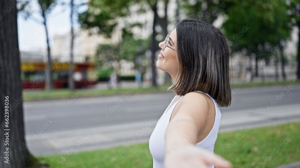 Young beautiful hispanic woman with open arms at the park in Vienna Young beautiful hispanic woman with open arms at the park in Vienna
