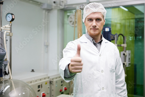 scientist smiling and thumbs up pose in testing lab