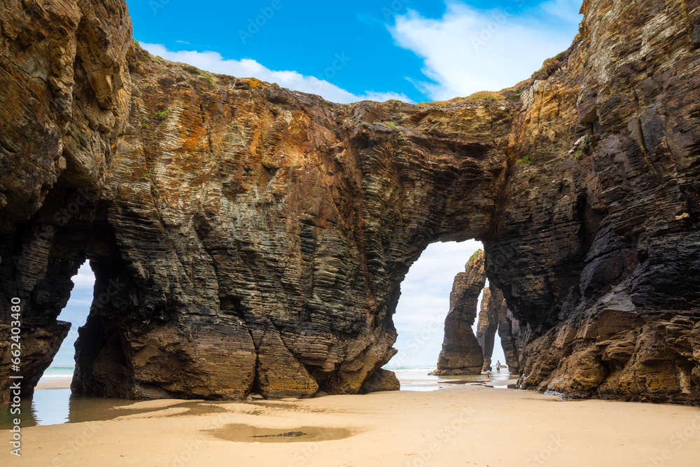 Natural rock arches Cathedrals beach, Playa de las Catedrales at Ribadeo, Galicia, Spain. Famous beach in Northern Spain Atlantic. Natural rock arch on Cathedrals beach in low tide