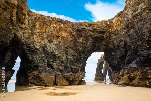 Natural rock arches Cathedrals beach, Playa de las Catedrales at Ribadeo, Galicia, Spain. Famous beach in Northern Spain Atlantic. Natural rock arch on Cathedrals beach in low tide photo