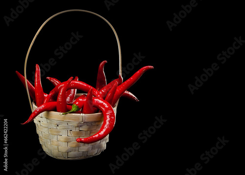 Red hot pepper in a basket on a dark background.