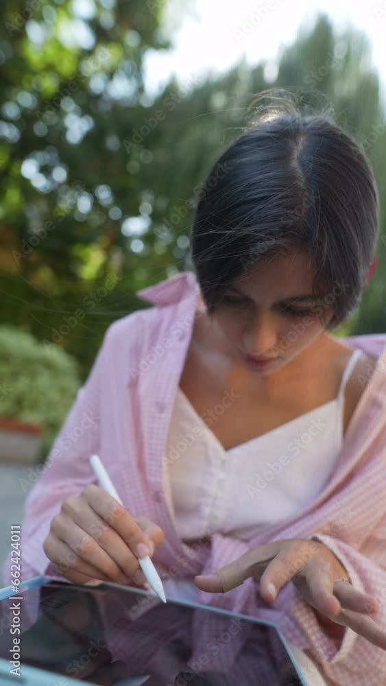 An appealing, young lady with a tablet, working outside on a summer day. An appealing, young lady with a tablet, working outside on a summer day.