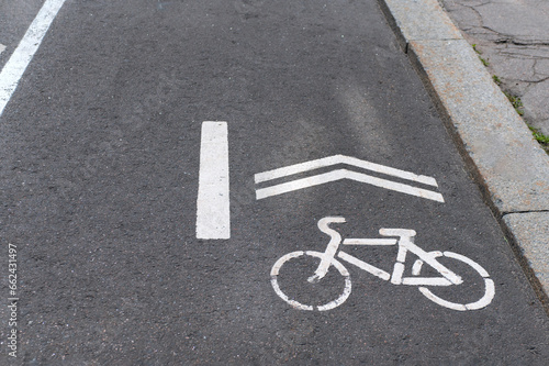 the designation of the bike path on the asphalt. Bicycle sign and the direction of application of white paint on asphalt