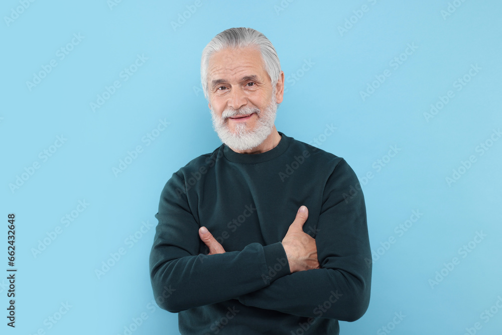 Portrait of handsome senior man on light blue background Portrait of handsome senior man on light blue background