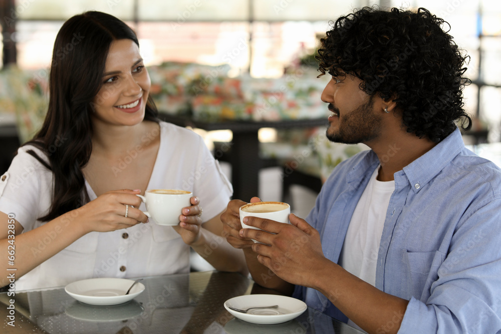 International dating. Happy couple enjoying tasty coffee in cafe International dating. Happy couple enjoying tasty coffee in cafe