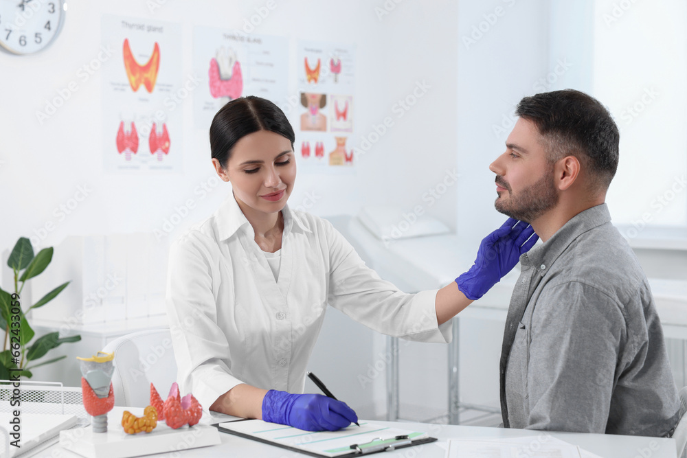 Fototapeta premium Endocrinologist examining thyroid gland of patient at table in hospital