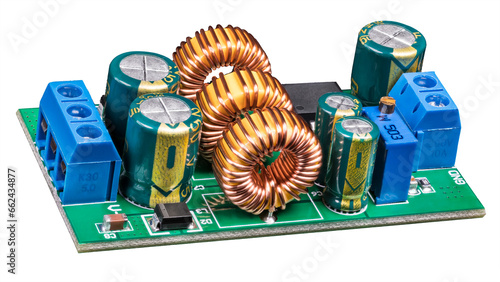 Electronic components on circuit board of power supply converter isolated on white background. Close-up of toroidal coils, electrolytic capacitors or resistor trimmer and screw terminals on green PCB. photo