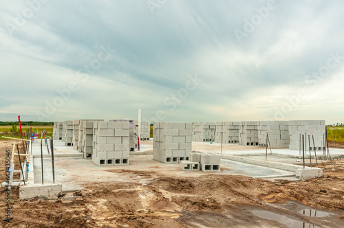 Front view, far distance of, stacks of cinder blocks, on concrete slab