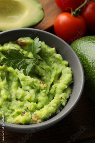 Delicious guacamole and different ingredients on table, closeup