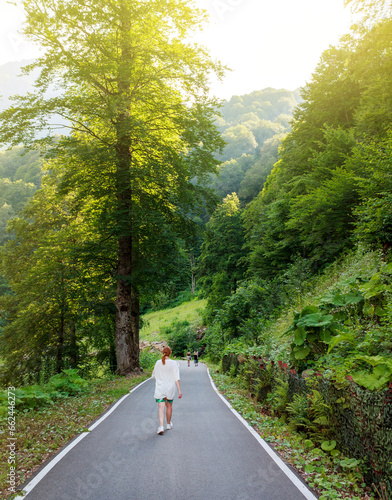 Hiking jogging along paths in a park in nature, national park, green lush grow stylish