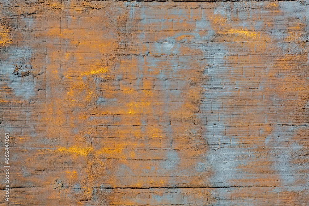 The background of the wall, stucco rough surface. Gold and blue. Background or texture for design
