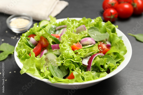 Delicious salad in bowl on grey table, closeup