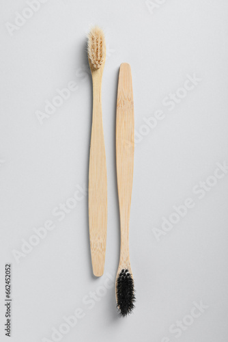 Old bamboo toothbrushes on white background, flat lay