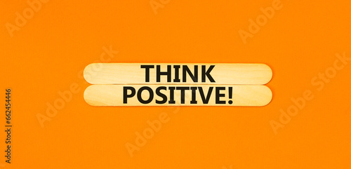 Think positive symbol. Concept words Think positive on wooden stick. Beautiful orange table orange background. Business, motivational think positive thinking concept. Copy space.