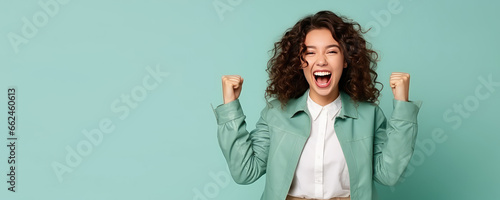Young joyful laughing woman in fashionable clothes making winning gesture isolated on pastel flat background with copy space. Banner template of promotion, winning, drawing gifts.
