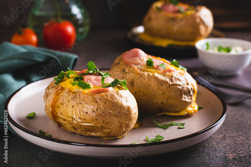 Baked whole potatoes with egg, sausages and herbs on a plate