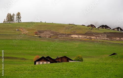 Traditional wooden cottage mountain houses in the green field in the dolomites. Housing in costadedoi Italian apls. Alpine region. photo