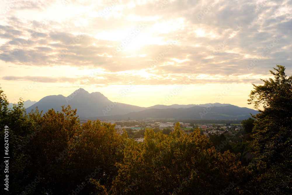 Sonnenuntergang in den Bergen mit Bäumen im Vordergrund Sonnenuntergang in den Bergen mit Bäumen im Vordergrund