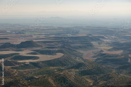 View of the Bardena Negra or Bardena black desert landscape of Bardenas Reales with vegetation, Navarra, Spain photo