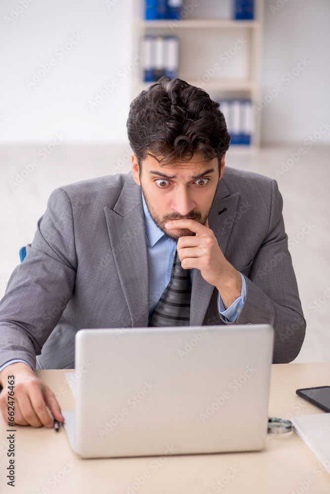 Young male employee and too much work in the office Young male employee and too much work in the office