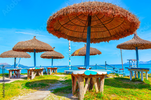 Hay umbrellas at tropical beach . Umbrellas and tables on the beach in Playa del Carmen, Mexico