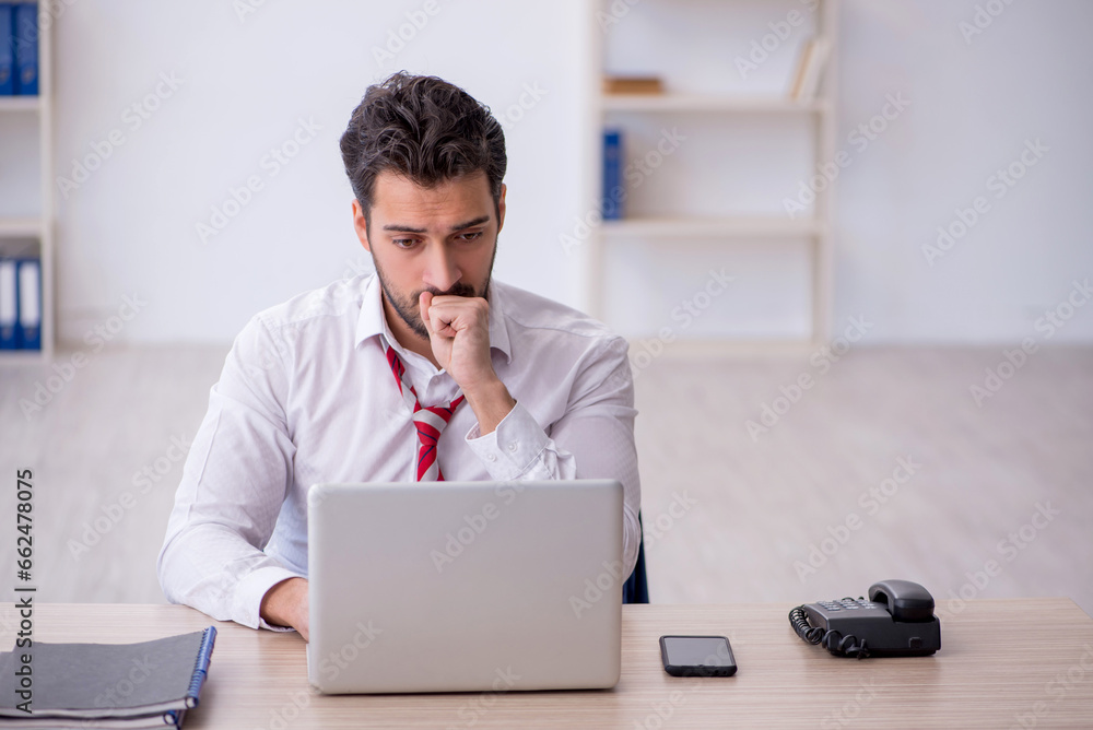 Young male employee working in the office Young male employee working in the office