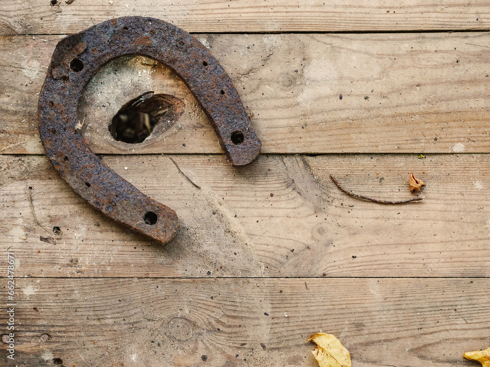 One old metal horse shoe on a simple wooden surface. Old symbol of luck. One old metal horse shoe on a simple wooden surface. Old symbol of luck.