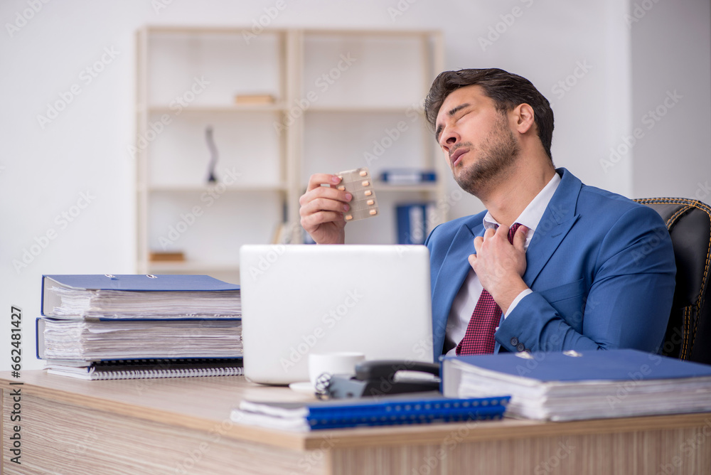 Young male employee feeling bad at workplace Young male employee feeling bad at workplace