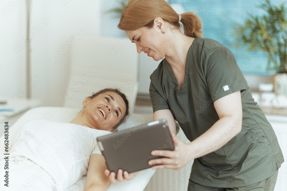 smiling massage therapist woman in massage cabinet with client smiling massage therapist woman in massage cabinet with client