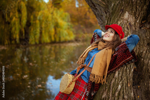 relaxed modern woman in jeans shirt and red hat with scarf