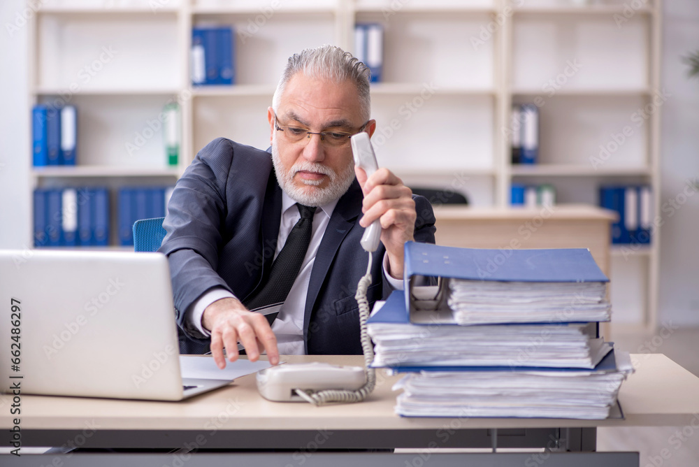 Old male employee and too much work at workplace Old male employee and too much work at workplace