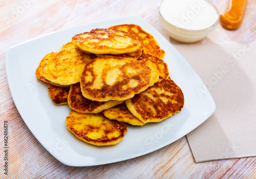 Sweet fritters with cottage cheese served with cream