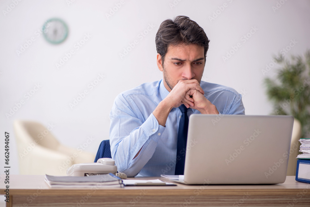Young male employee working in the office Young male employee working in the office
