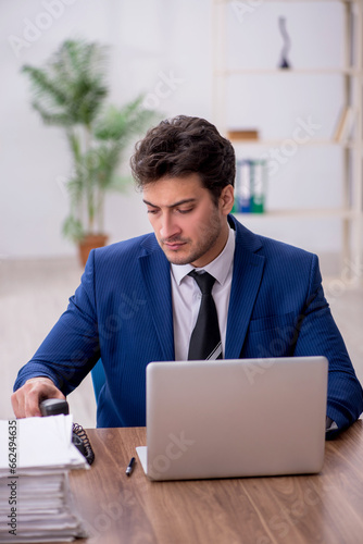 Young male employee and too much work in the office