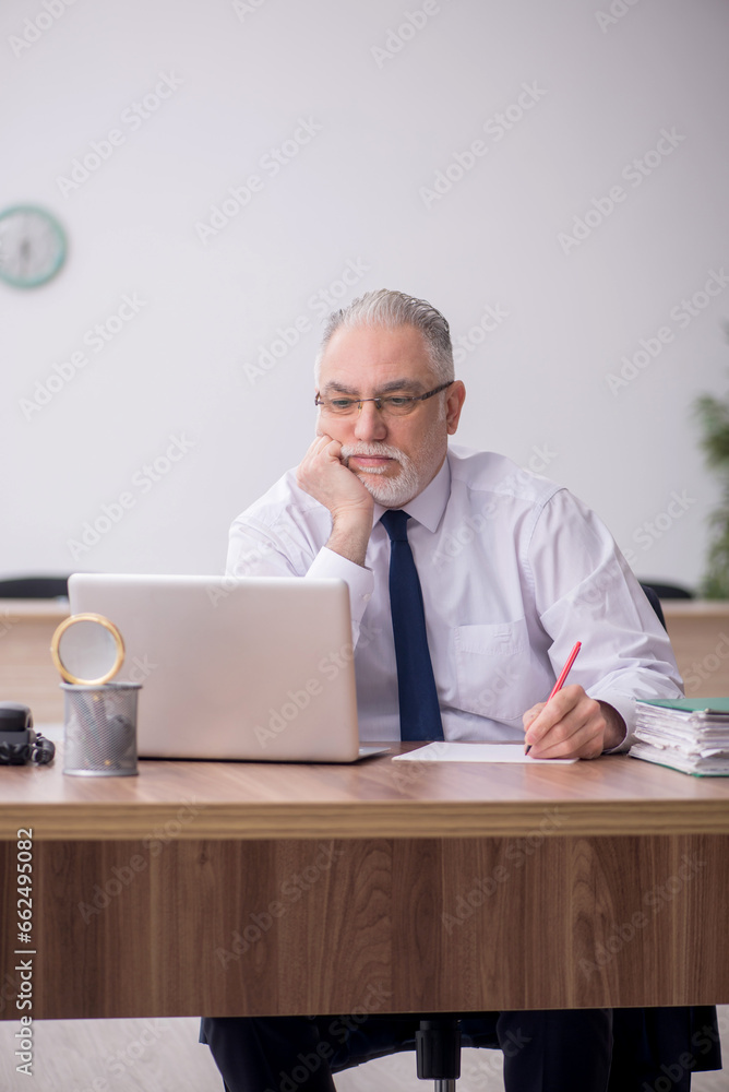Old male employee working in the office Old male employee working in the office