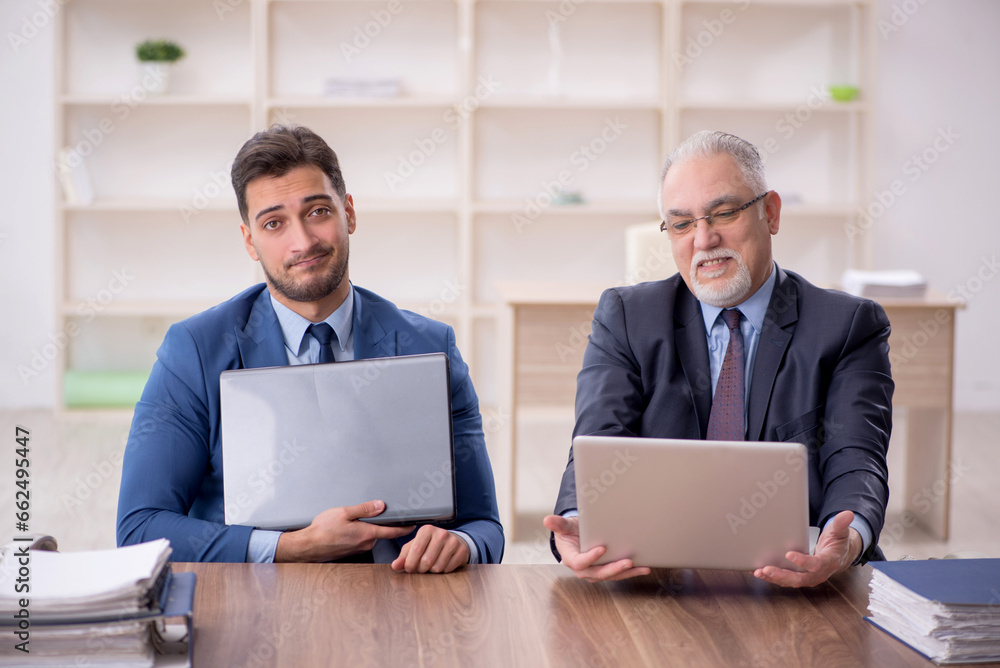Two male employees working in the office Two male employees working in the office