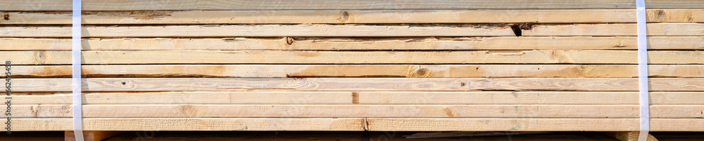 Naklejka premium Side view of a stack of lumber, materials for building a new house 