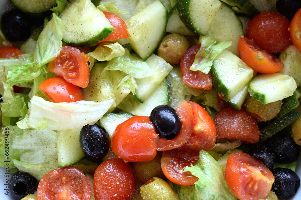 Close up Mediterranean salad with lettuce, cucumber, cherry tomatoes and olives