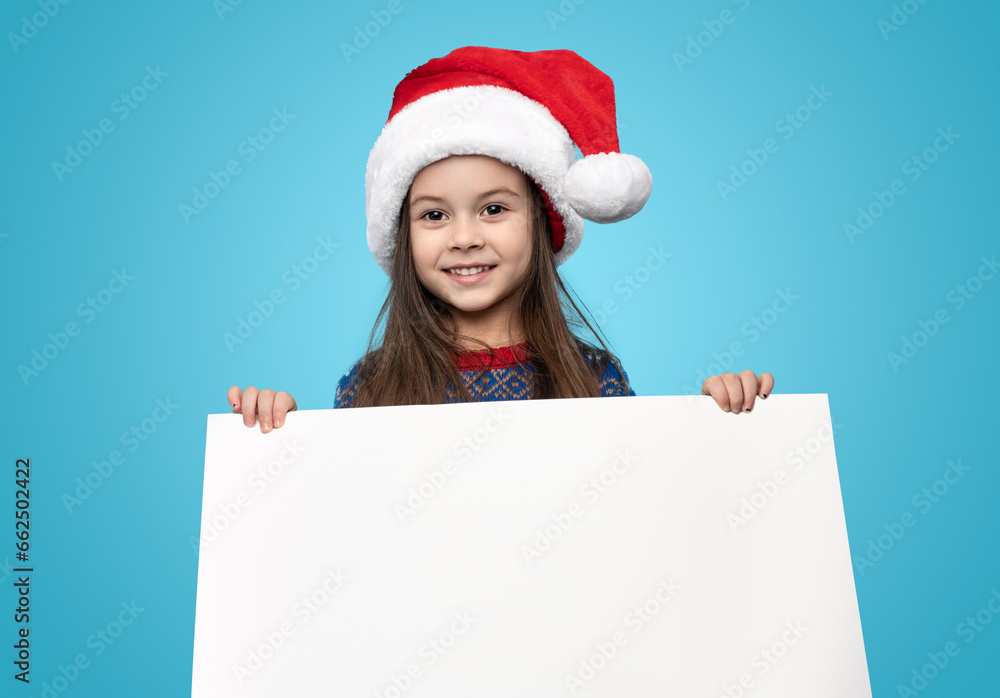 Smiling girl in santa hat showing blank Smiling girl in santa hat showing blank
