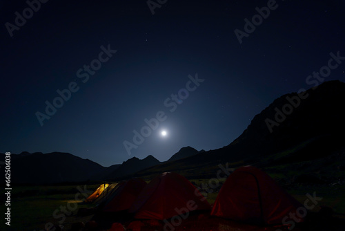 Super colorful landscape of night sky with dark mountains at foreground.