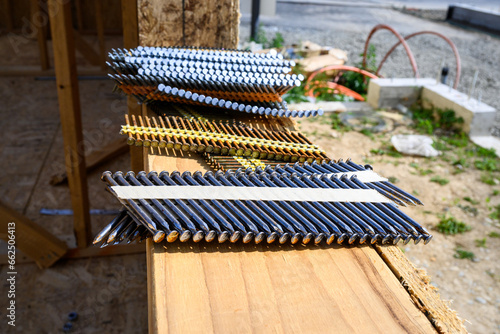 Fotografija Stacks of framing nails sitting on the windowsill of a house under construction