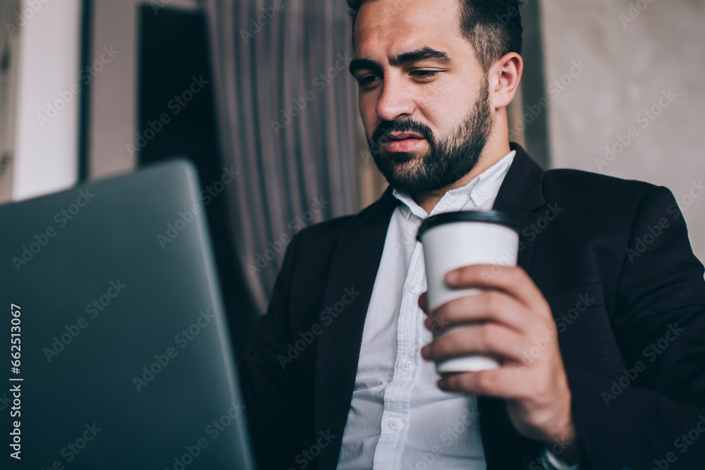 Businessman drinking takeaway coffee and working with laptop Businessman drinking takeaway coffee and working with laptop