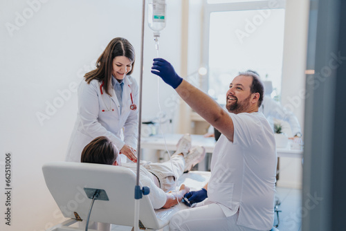 Photos A man undergoing infusion therapy in a hospital room, received by a specialist for a medical illness