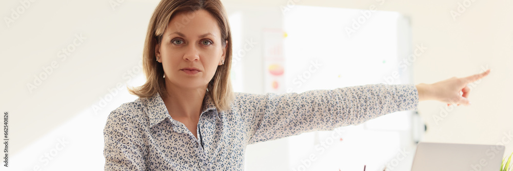 Angry businesswoman points finger to door asking to leave Angry businesswoman points finger to door asking to leave